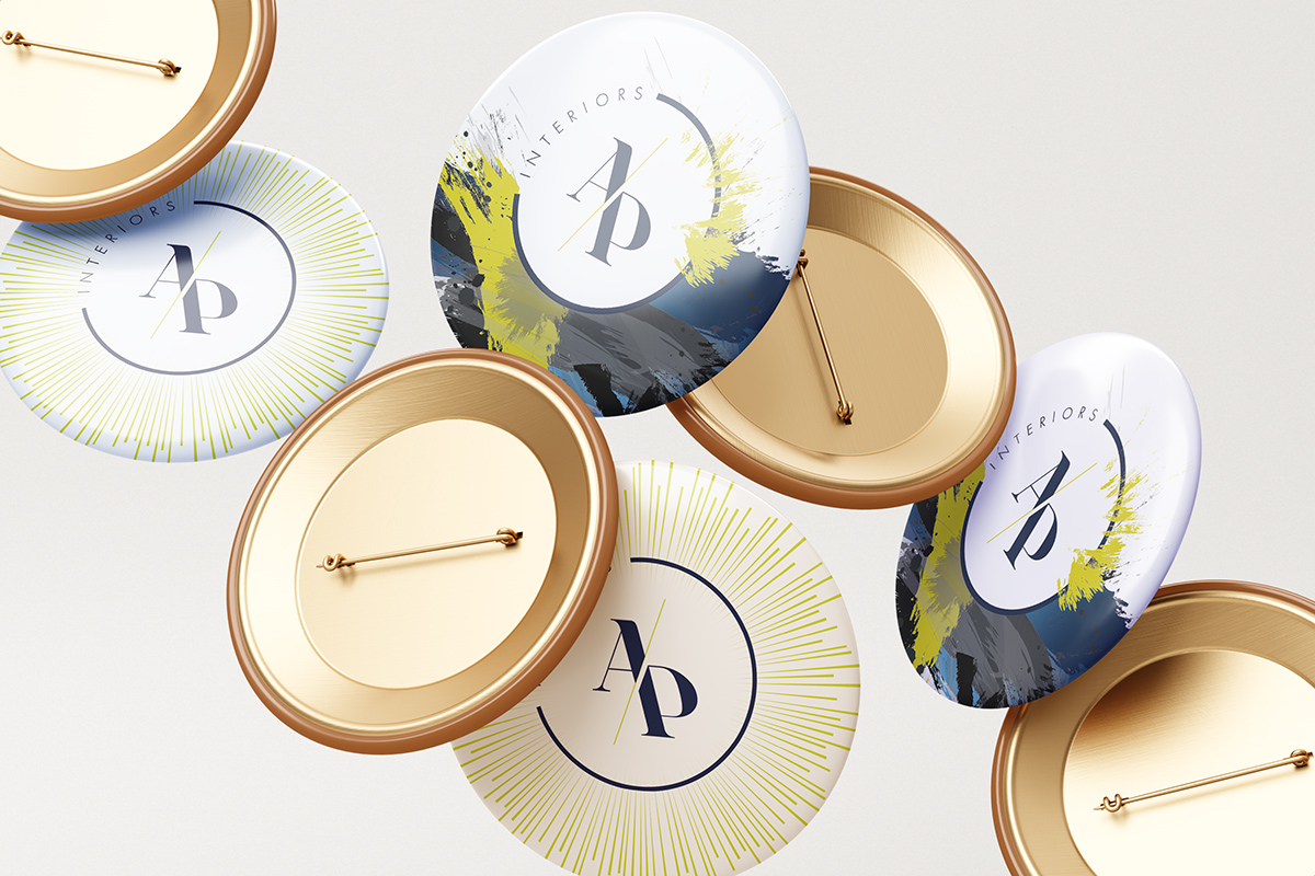 Enamel and gold pin badges printed with the AP Interiors monogram in several colourways