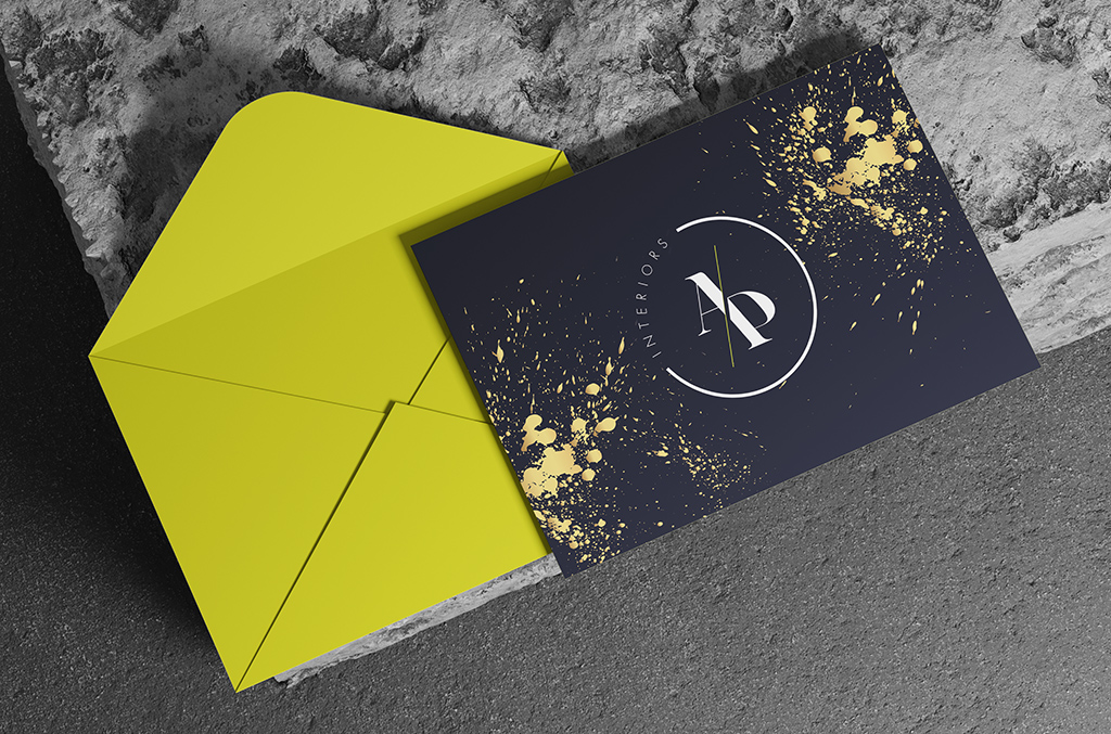 Promotional card and envelope set: chartreuse envelope with a navy card carrying the monogram in gold splatter