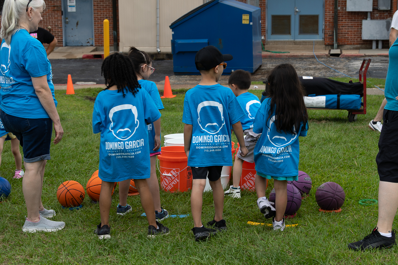 Children in the firm's branded t-shirts taking part in an outdoor community sports day